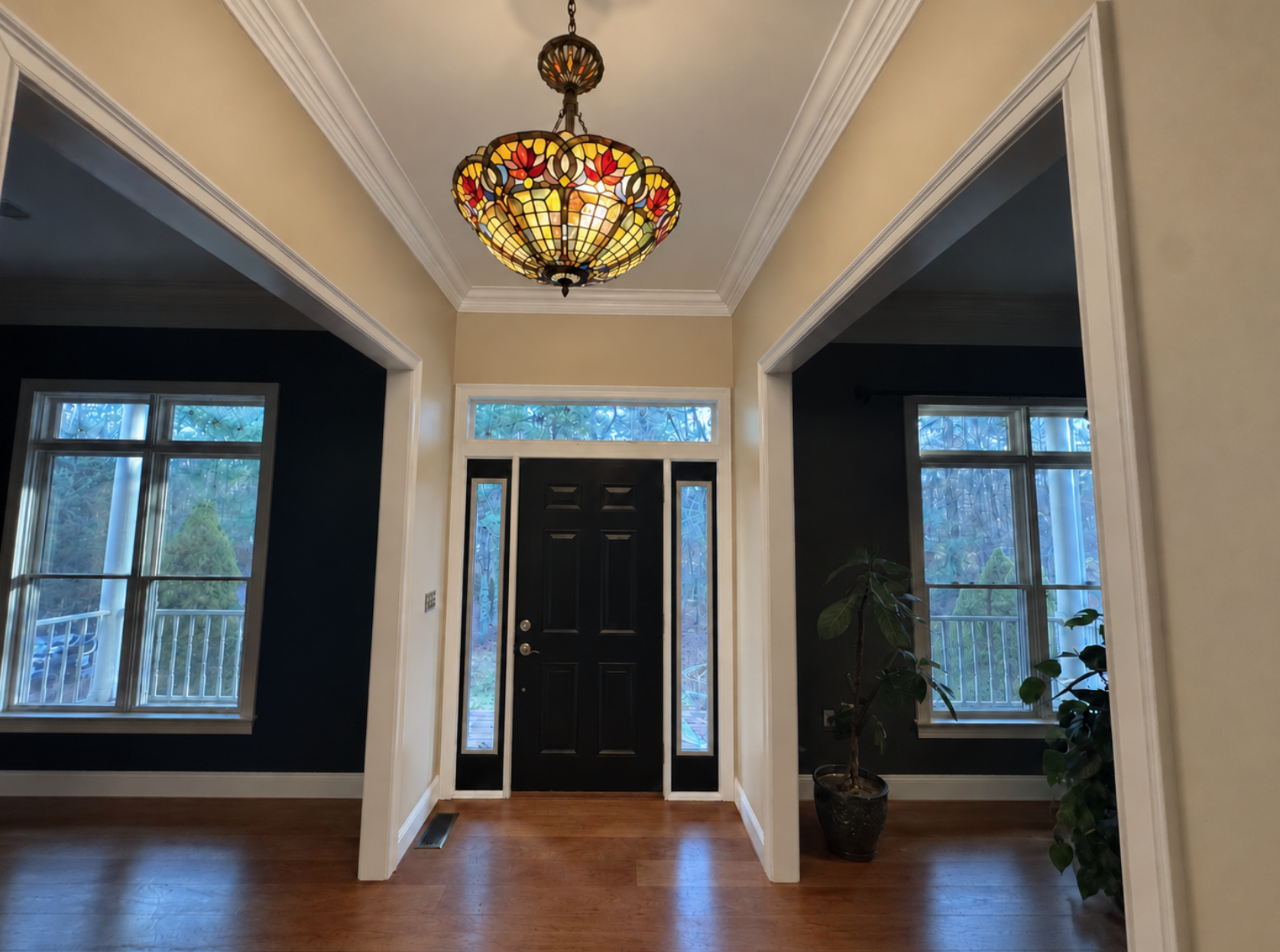 Entryway painted by PTG Painting in Norton, MA, with a black front door, white trim, wood floors, an