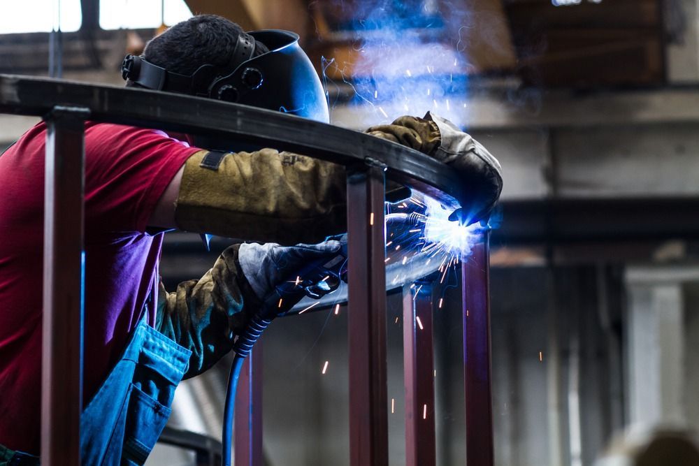 A man is Welding a Piece of Metal in a Factory — Shearwater Engineering in Forster, NSW
