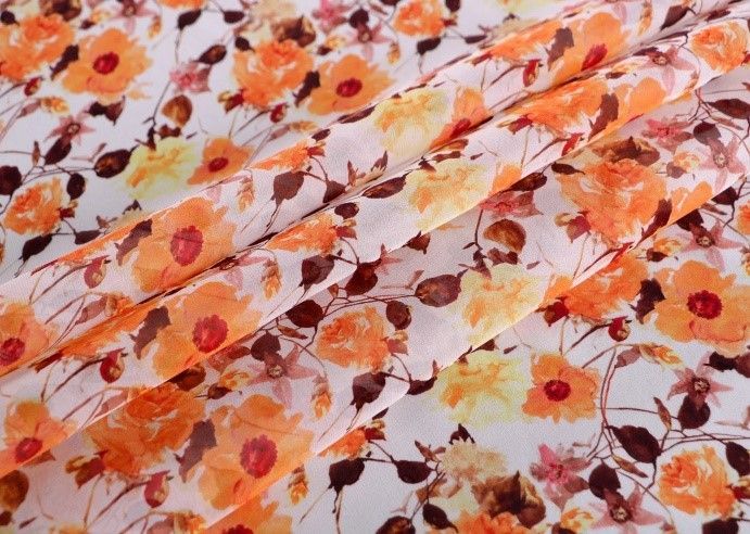 A close up of a piece of fabric with orange flowers on it.