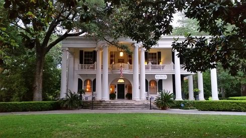 a large porch with tables and chairs on it .