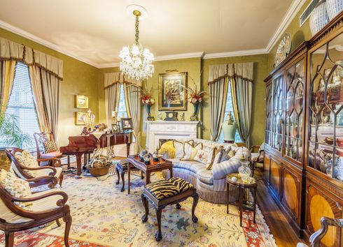 Parlor with piano and chandelier.