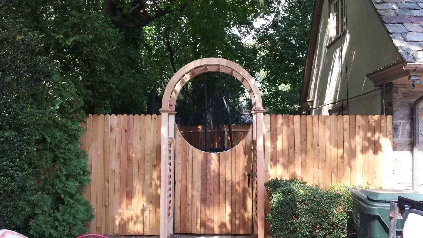 A wooden fence with a round arch in the middle of it.