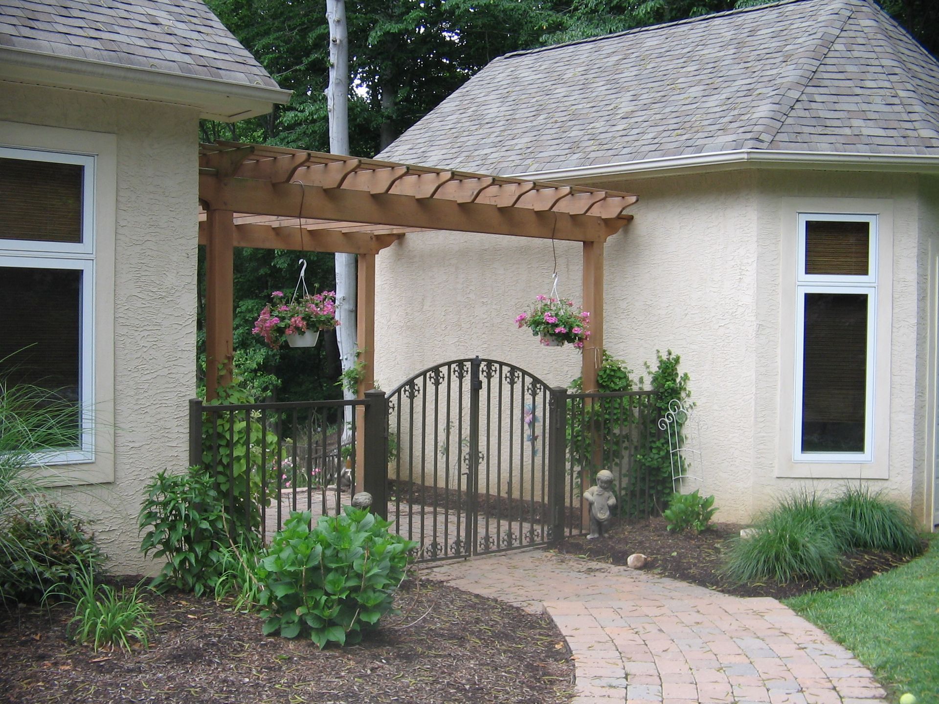 A house with a pergola and a gate in front of it