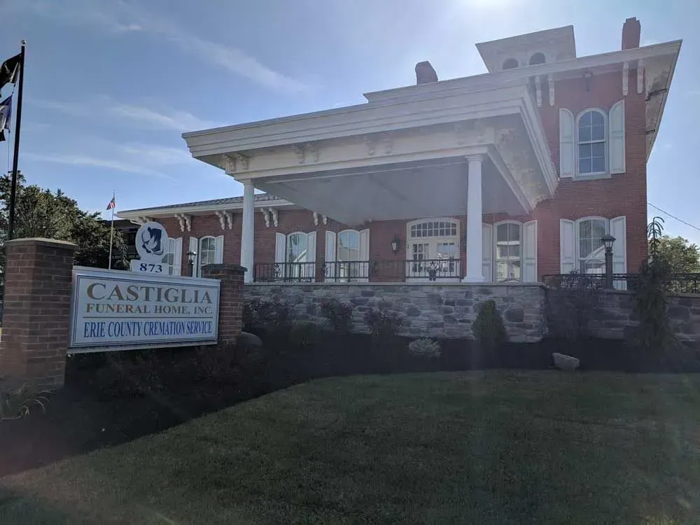 Castiglia Funeral Home building with white columns and brick exterior under a bright sky