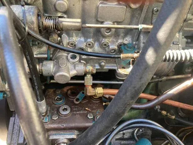 Close-up of a diesel engine showing fuel lines, a pump, and various fittings.