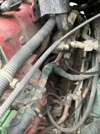 Engine components: hoses, wires, and tubes in a cluttered, dusty engine bay.