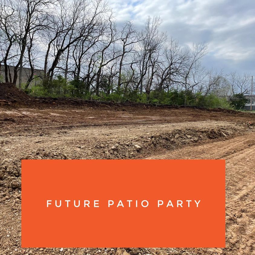 Cleared dirt lot under cloudy sky with orange banner reading “FUTURE PATIO PARTY”