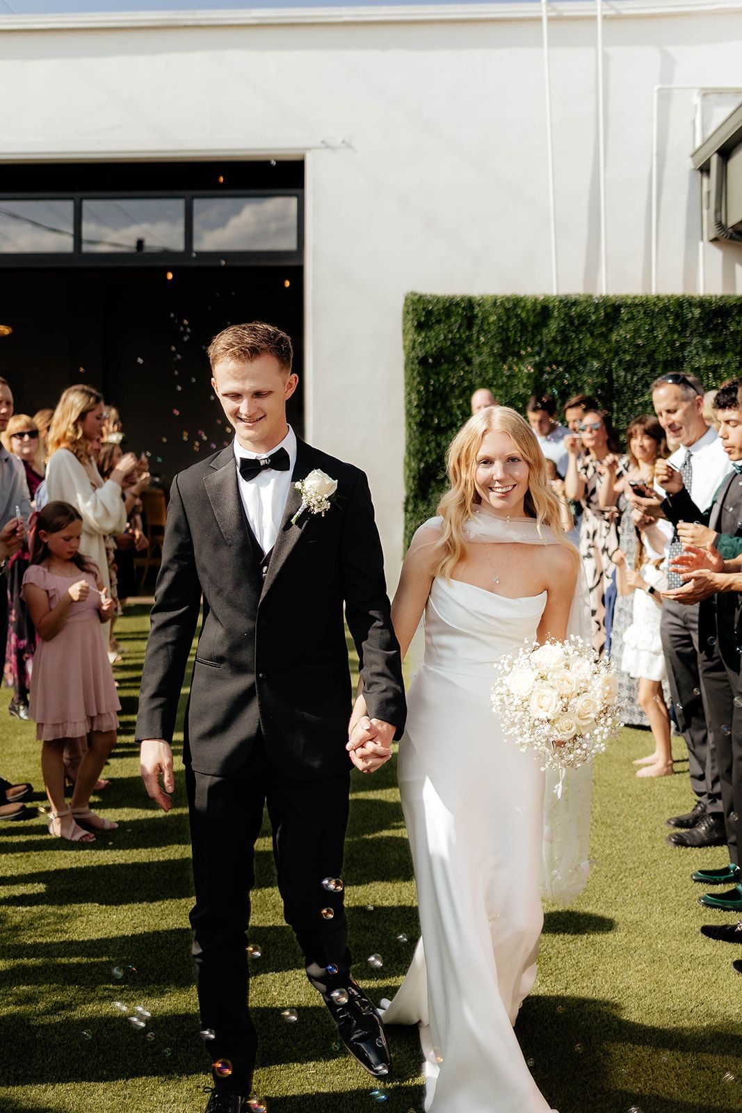 Bride and groom walking through outdoor patio space at Bestow Events in Longmont, CO.