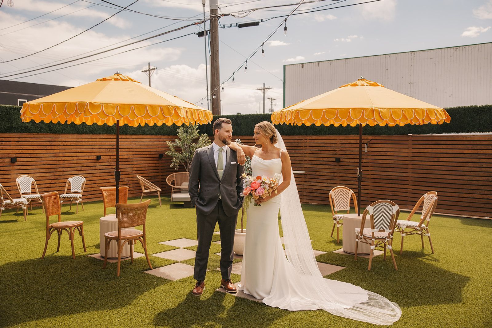 Bride and groom posing in the outdoor garden patio of Bestow Events in Longmont, CO.