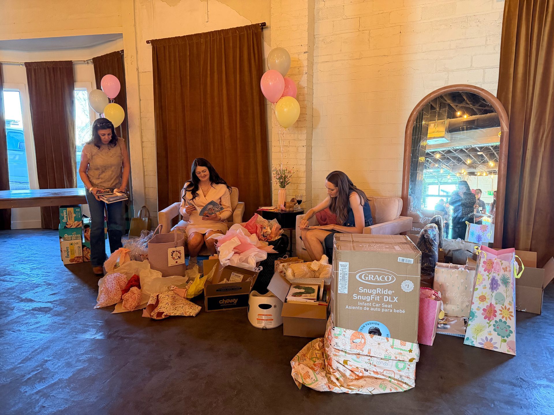 Mom to be opening gifts during indoor baby shower at Bestow Events in Longmont, Co.