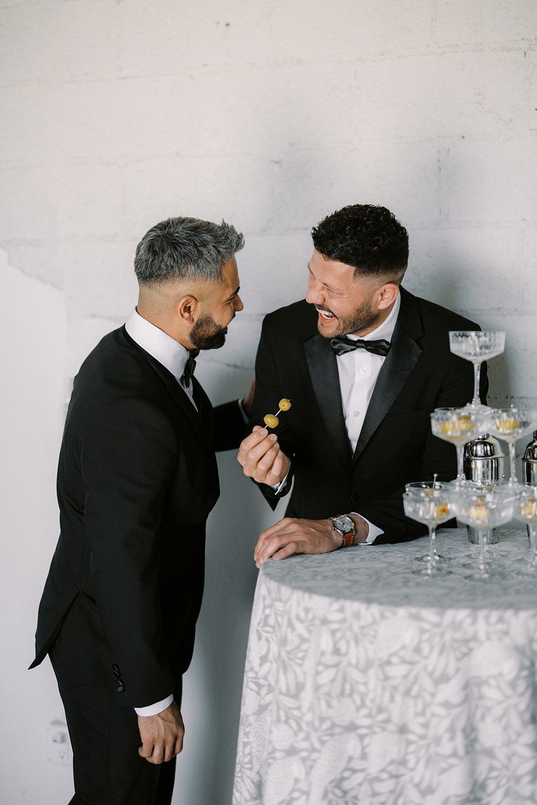 Couple laughing next to champagne glass tower at Bestow Events.