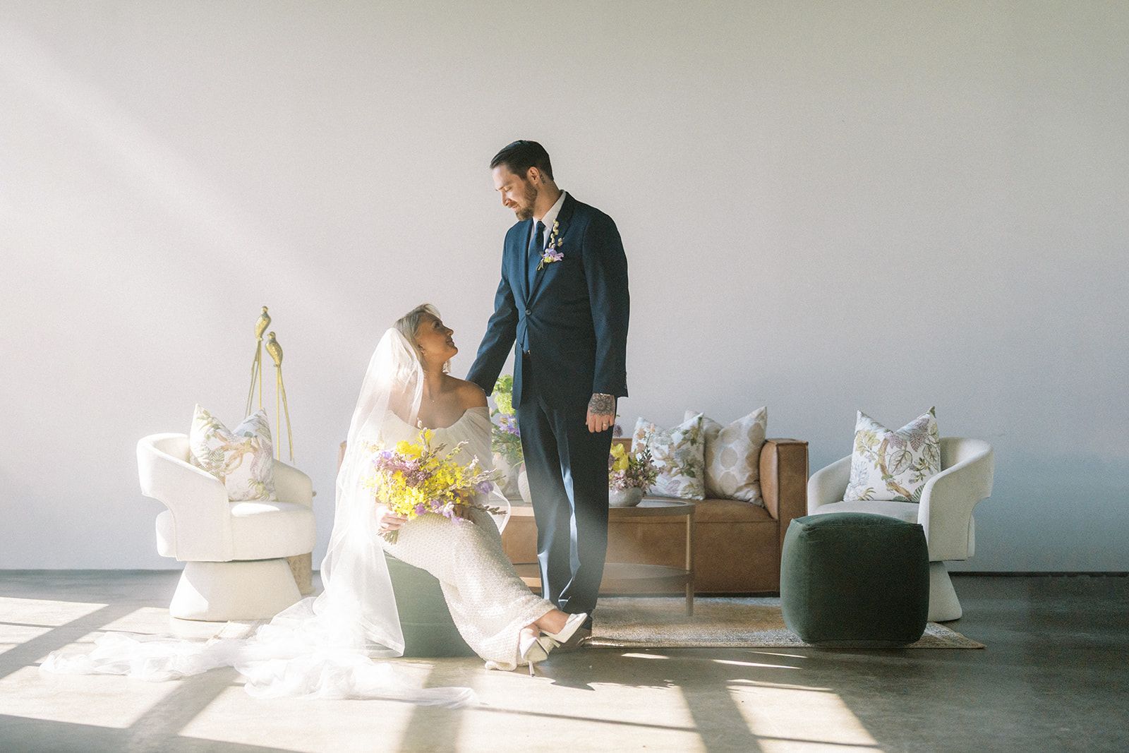 Bride and groom posing on lounge furniture at Bestow Events in Longmont, CO.