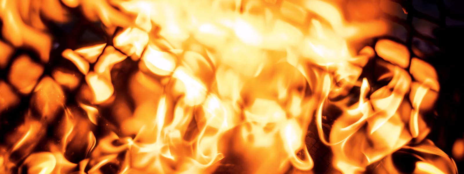 Outdoor grill repair in Fresno, CA: close-up of BBQ grill flames serviced by Bauman’s Appliance