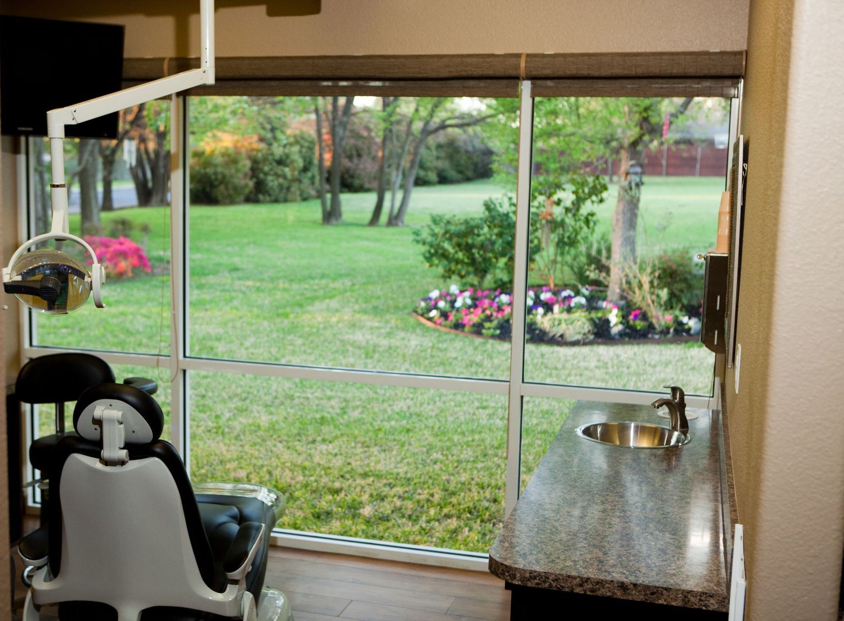 A dental office with a dental chair and a sink.