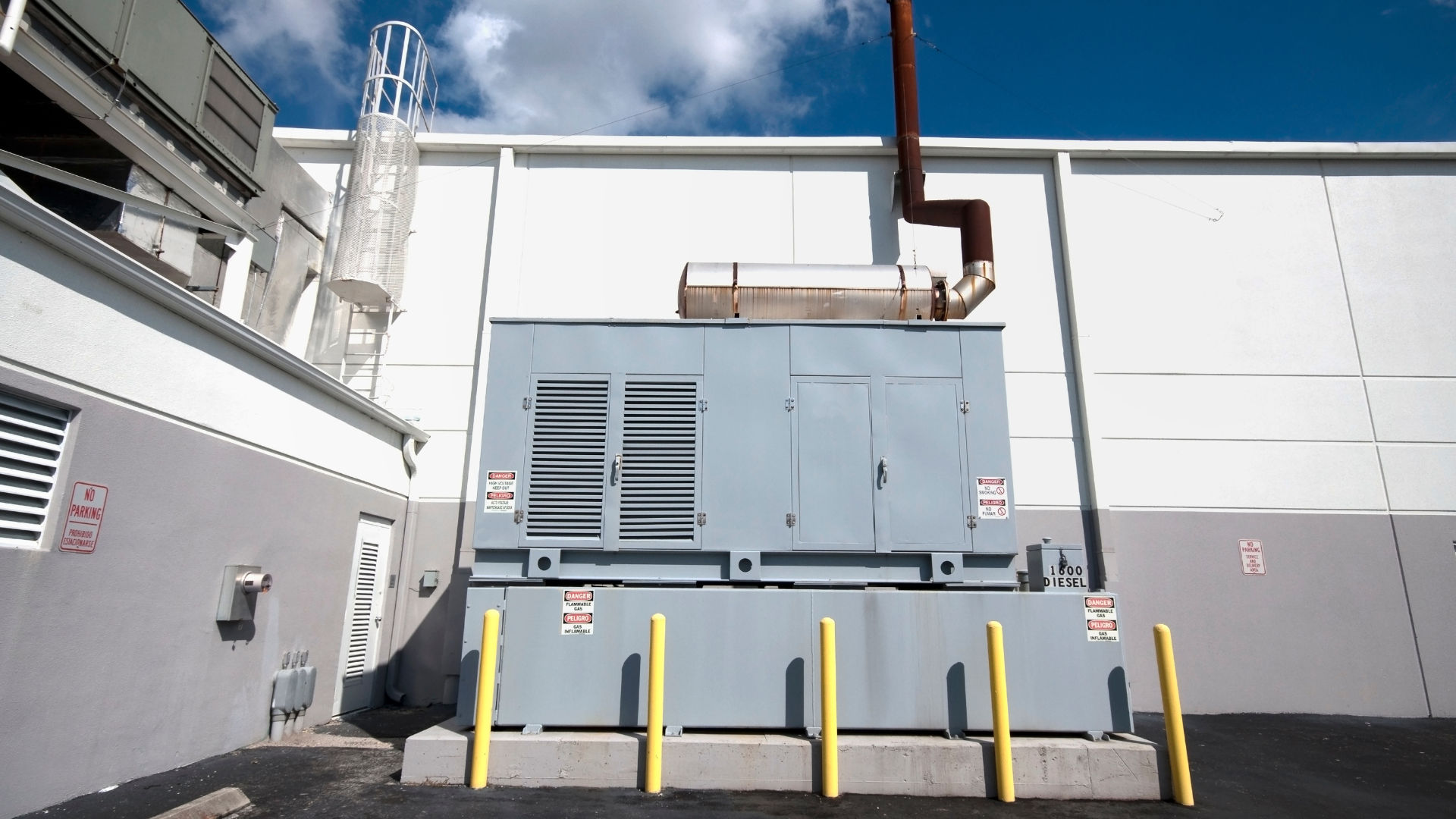 A large generator is sitting outside of a building