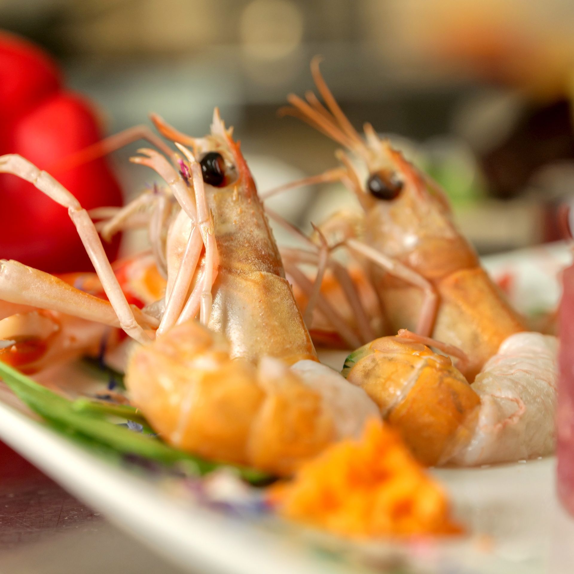 Piatto con gamberi e frutti di mare guarniti con uova di pesce arancioni, primo piano di un piatto da ristorante.