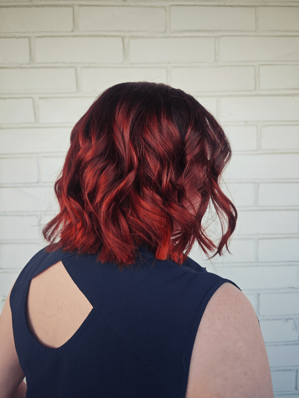 a woman with short copper red hair wearing a black T-shirt
