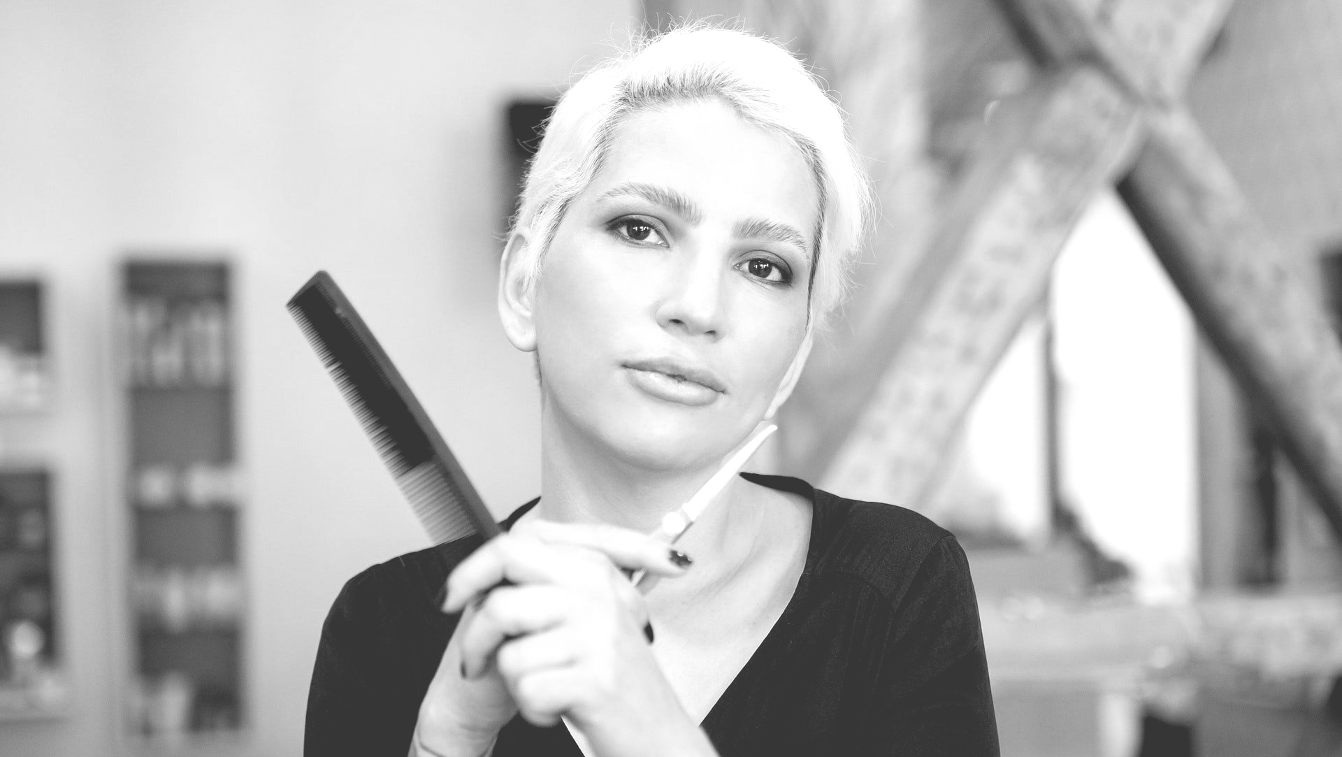 A woman is holding a pair of scissors in her hand.