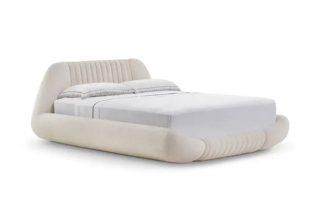 Cama de madeira com cabeceira de vime, lençóis brancos.