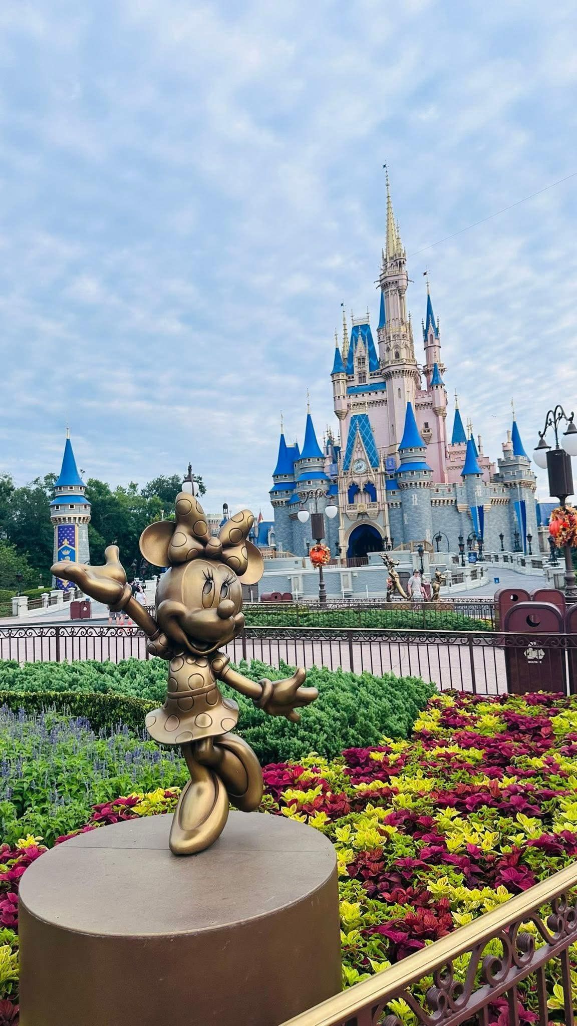Mickey Mouse topiary in front of Cinderella Castle with colorful flower beds at Disney World