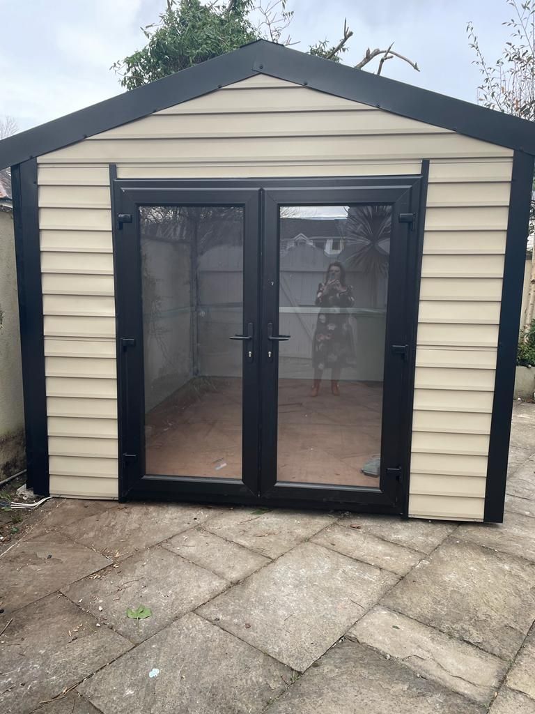 A shed with a woman standing in front of it.