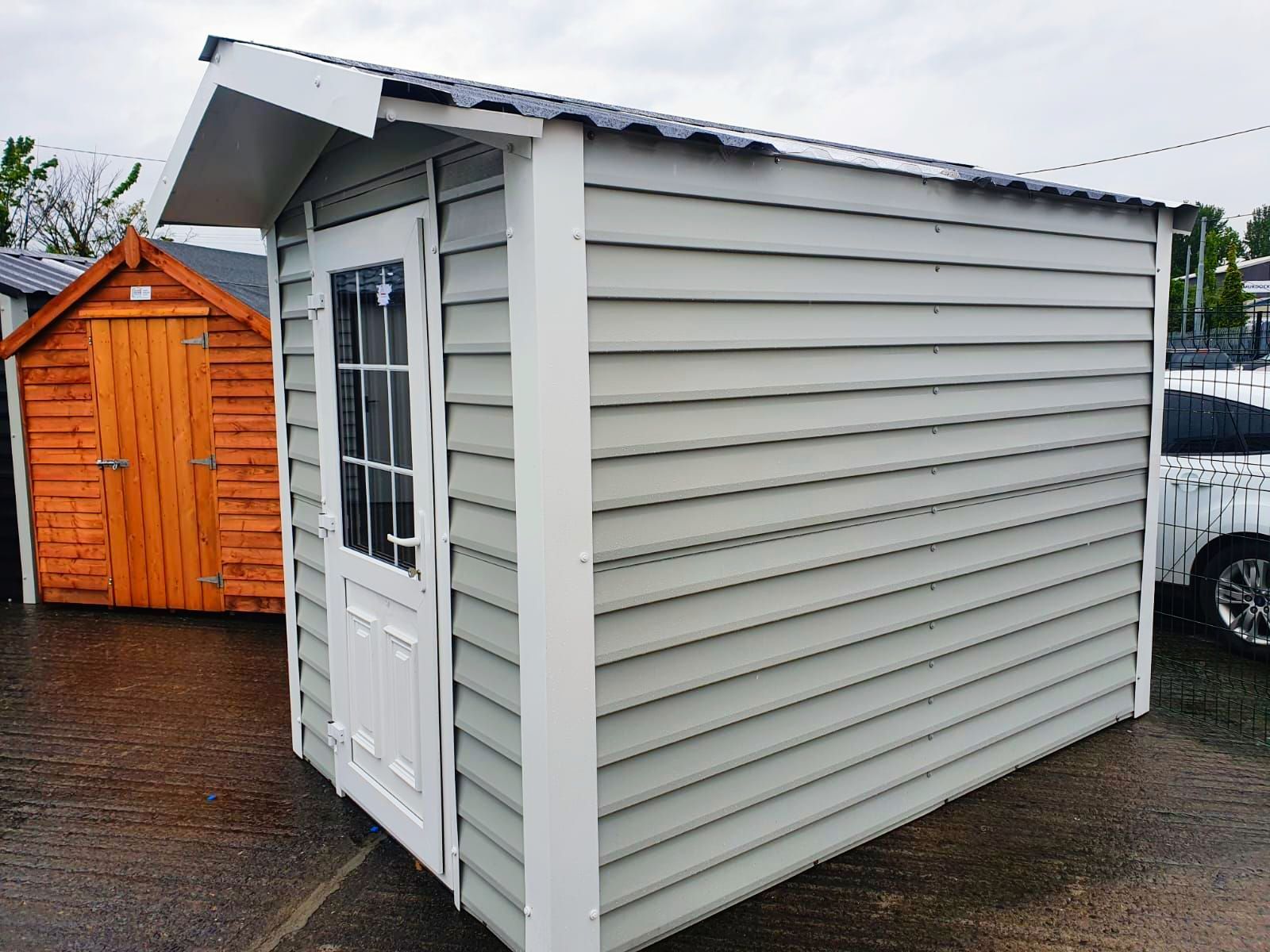 A small white shed is sitting next to a wooden shed.