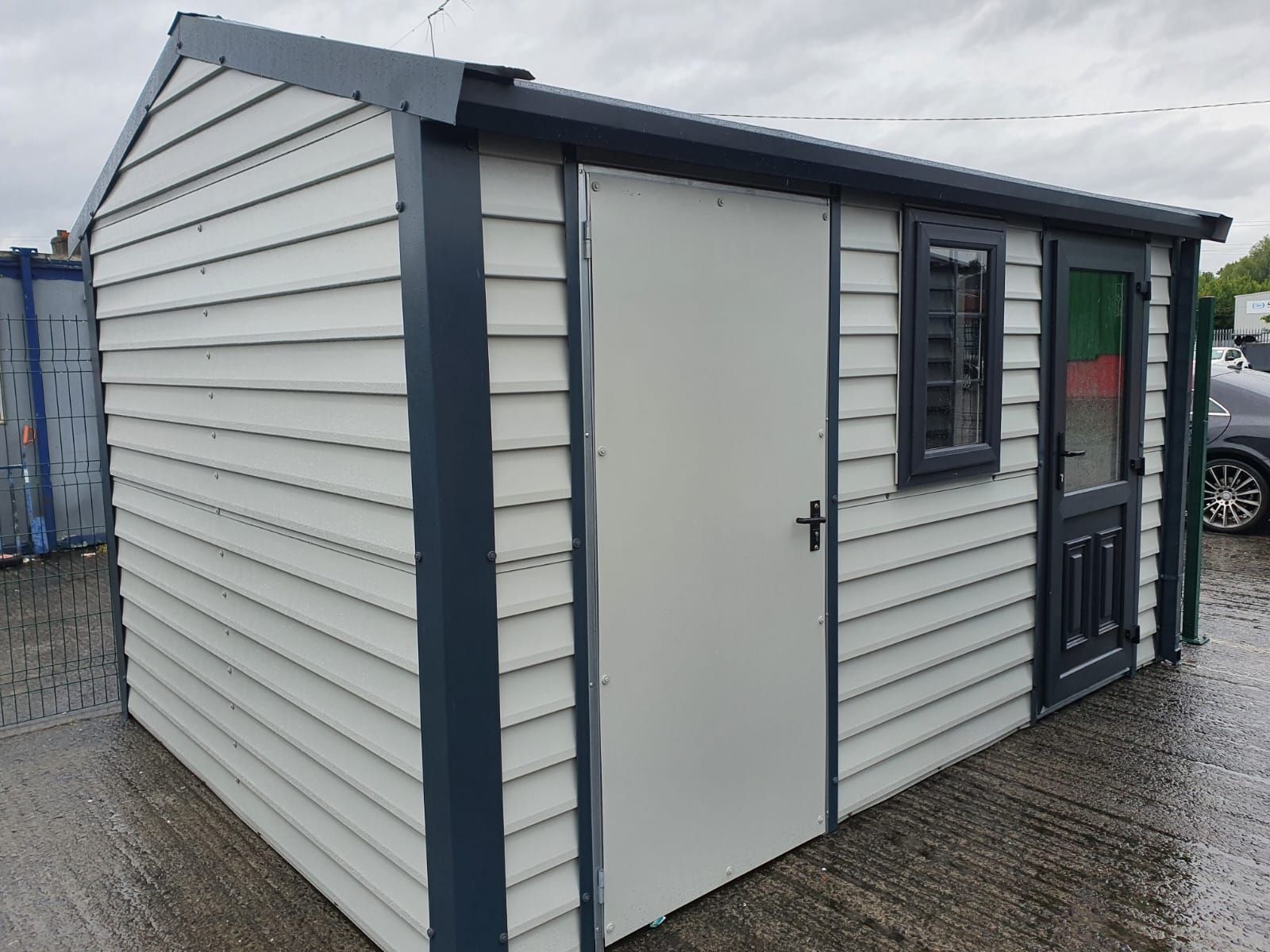 A white and black shed with a door and window