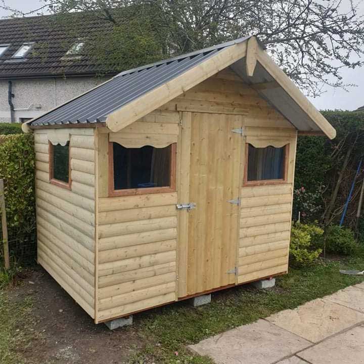 A small wooden shed with a roof and windows
