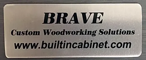 A metal sign that says brave custom woodworking solutions www.builtincabinet.com