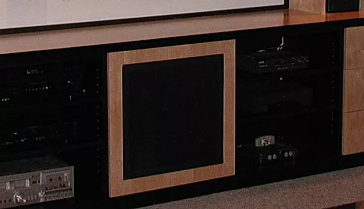 A projector screen is behind a wooden entertainment center