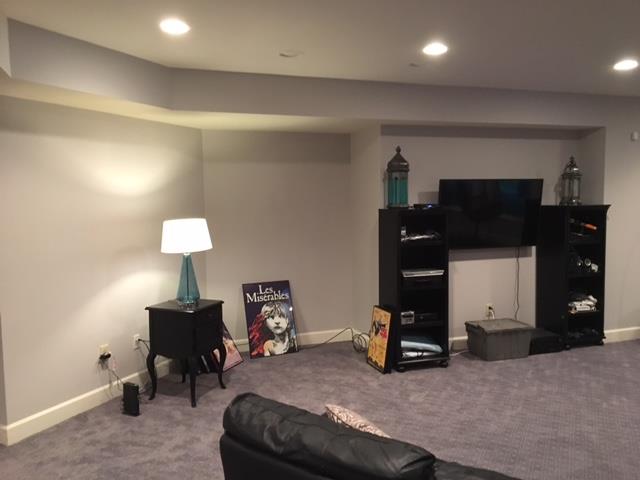 A living room with a black couch and a tv