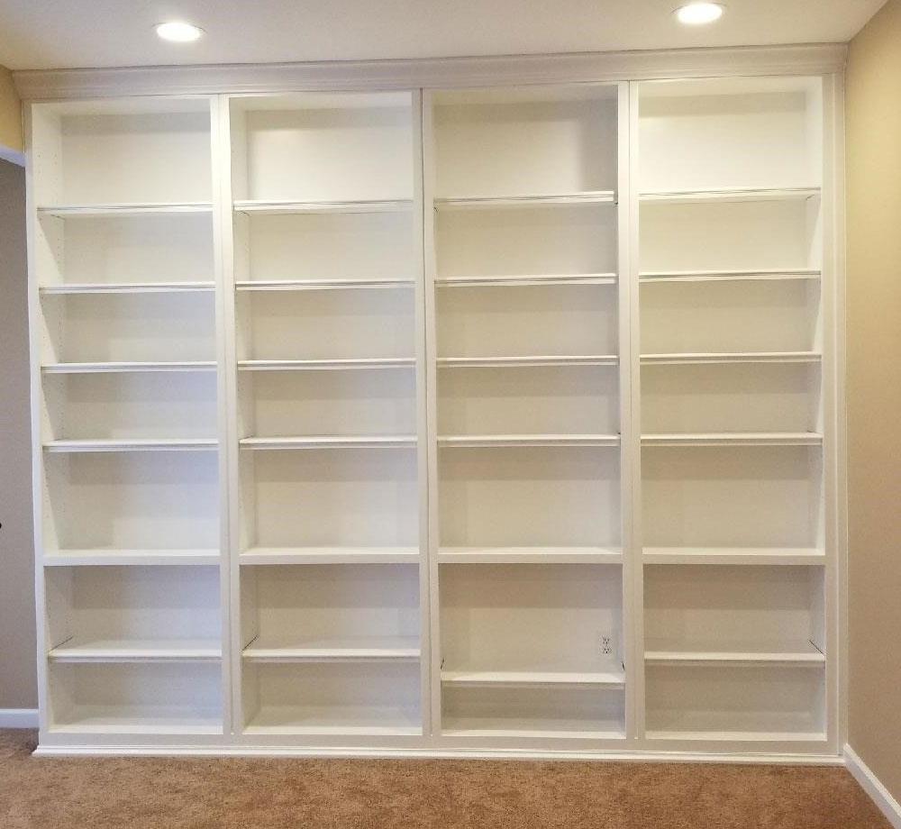 A room with a lot of shelves and a carpeted floor.