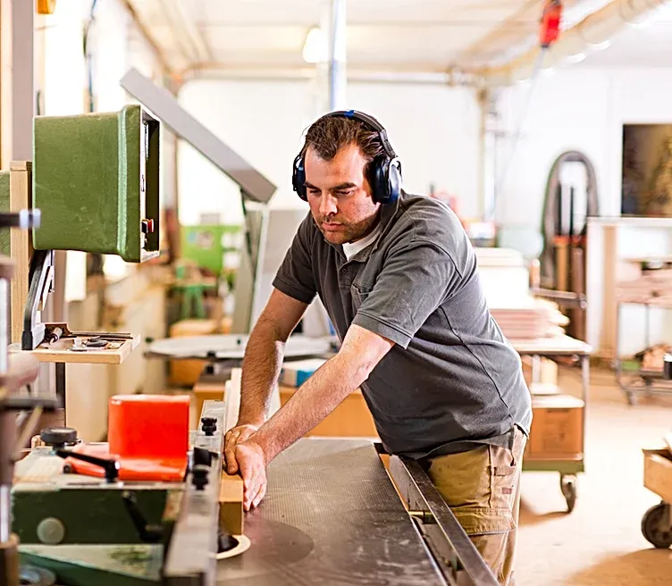 A man wearing headphones is working on a machine