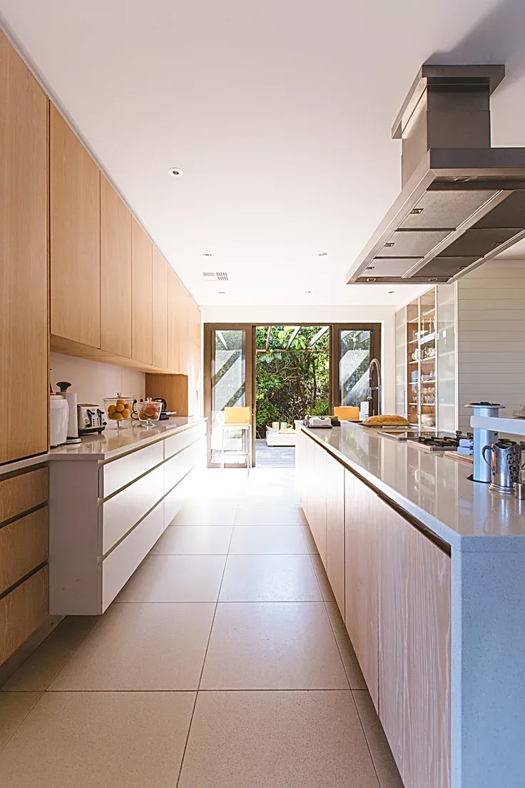 A kitchen with wooden cabinets and white counter tops