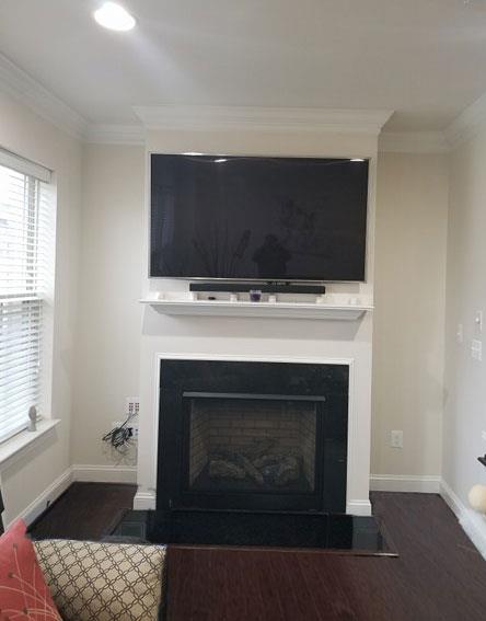 A living room with a fireplace and a flat screen tv.