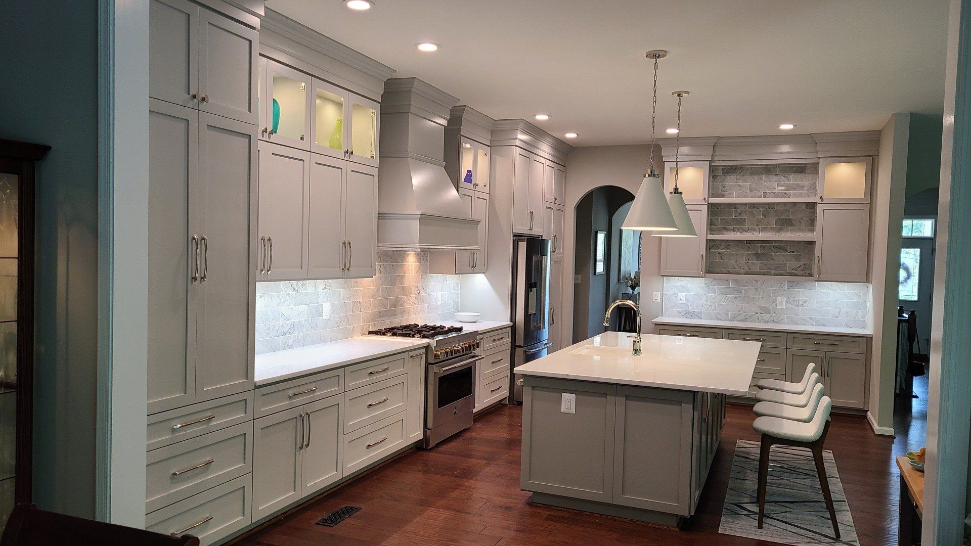 A kitchen with white cabinets and a large island
