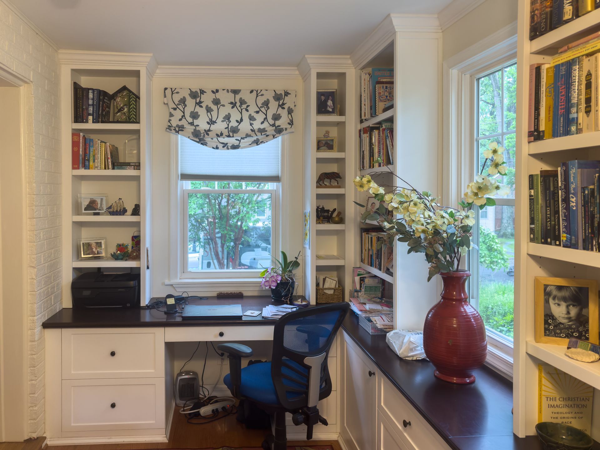 A room with lots of white shelves and cabinets