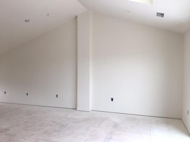 An empty room with white walls and tile floors