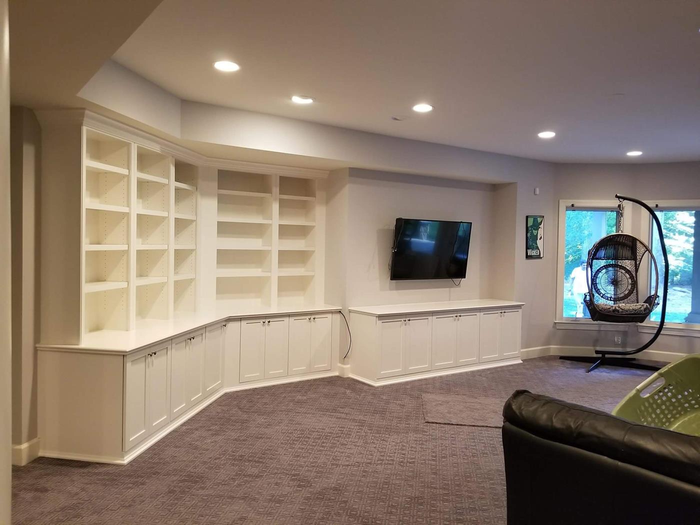 A living room with lots of shelves and a flat screen tv