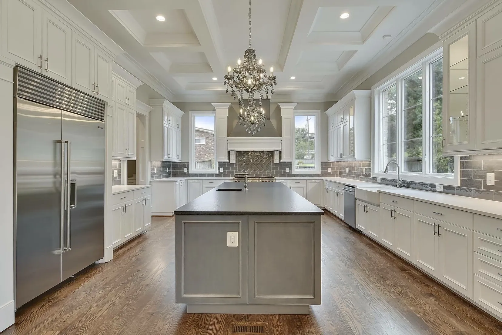 A large kitchen with white cabinets and stainless steel appliances