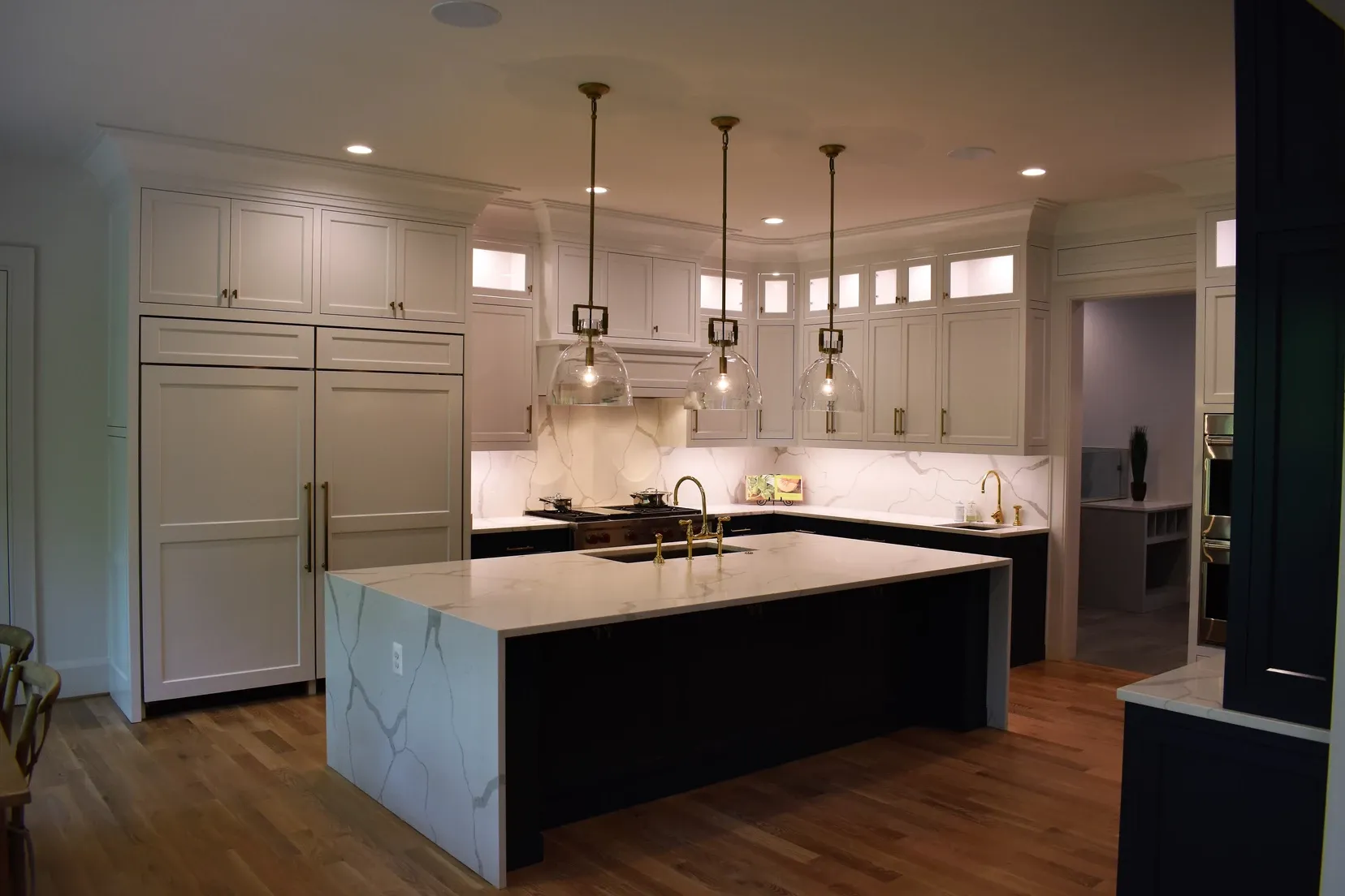 A kitchen with a large island and white cabinets