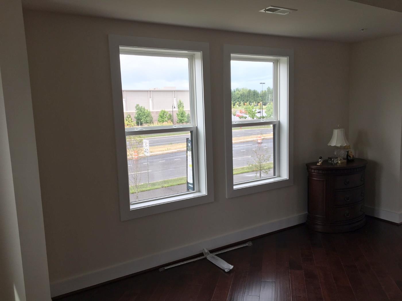 A living room with two windows and a lamp