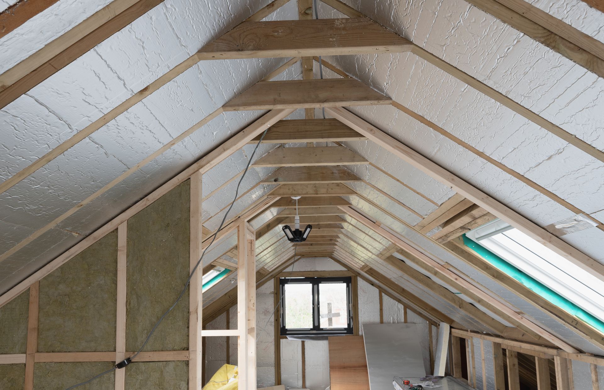 Interior attic framing with insulation and a small window