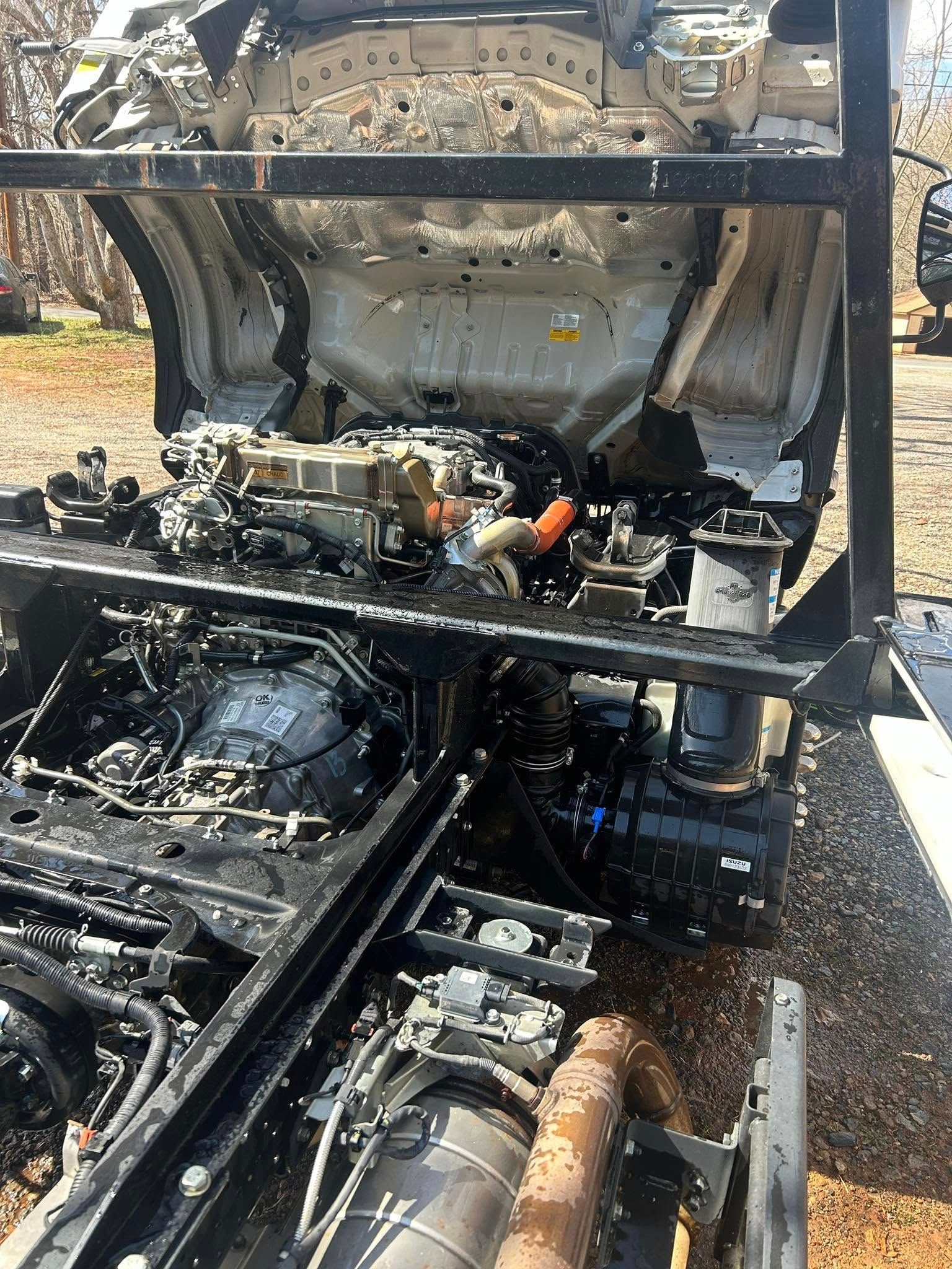 Charred vehicle engine compartment with extensive fire damage and melted components