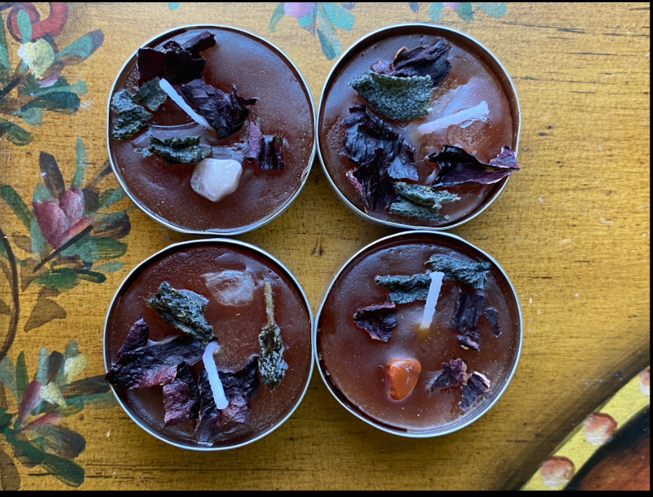 Four small bowls of red soup garnished with herbs on a yellow patterned tablecloth.