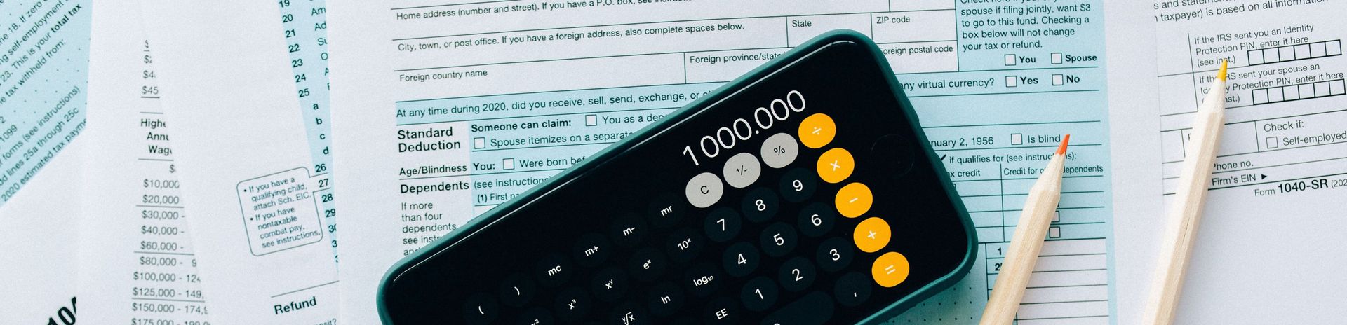 A calculator is sitting on top of a piece of paper next to a pencil.