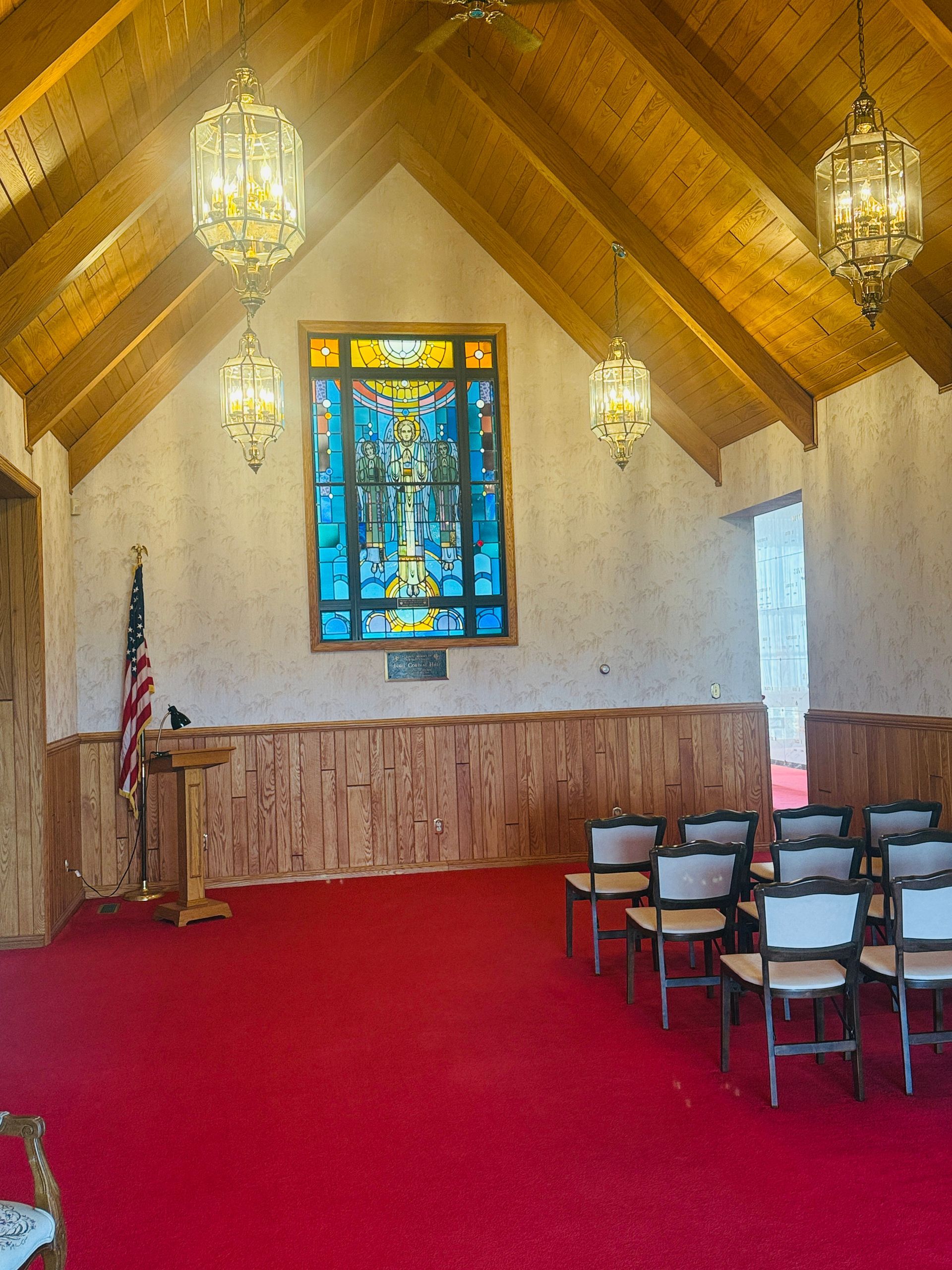chapel photo with benches, altar, stained glass, and tall wooden decorative ceiling