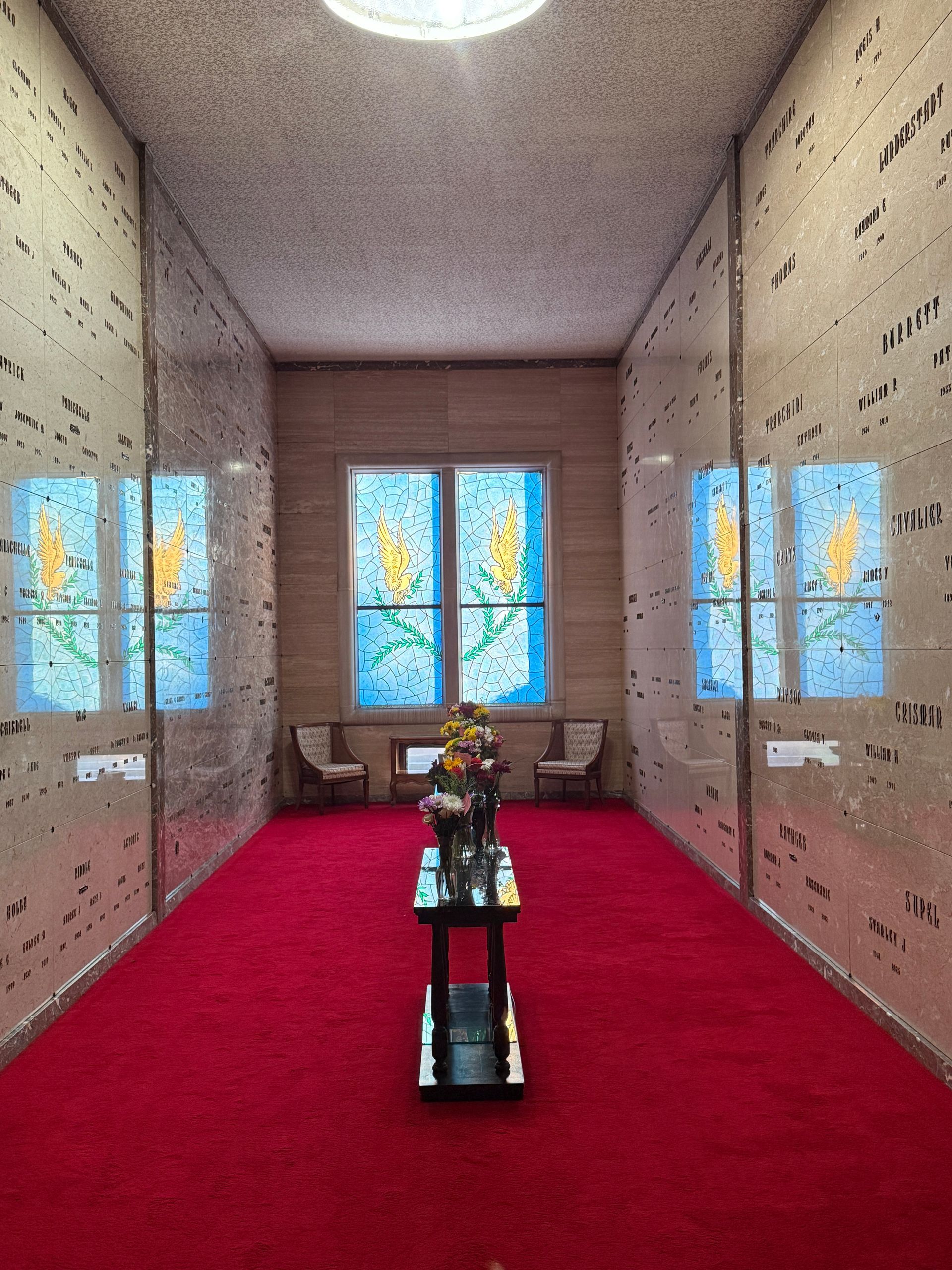 stone mausoleum graves in wall, stained glass
