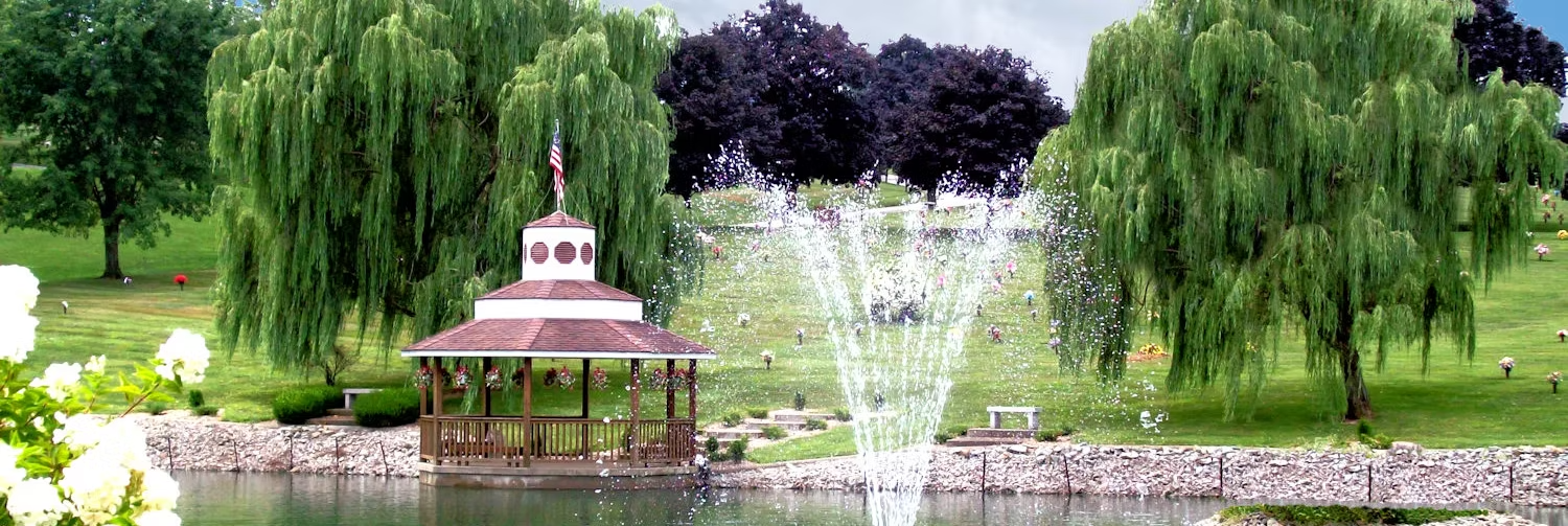 scenic property photo featuring a gazebo , pond, and fountain