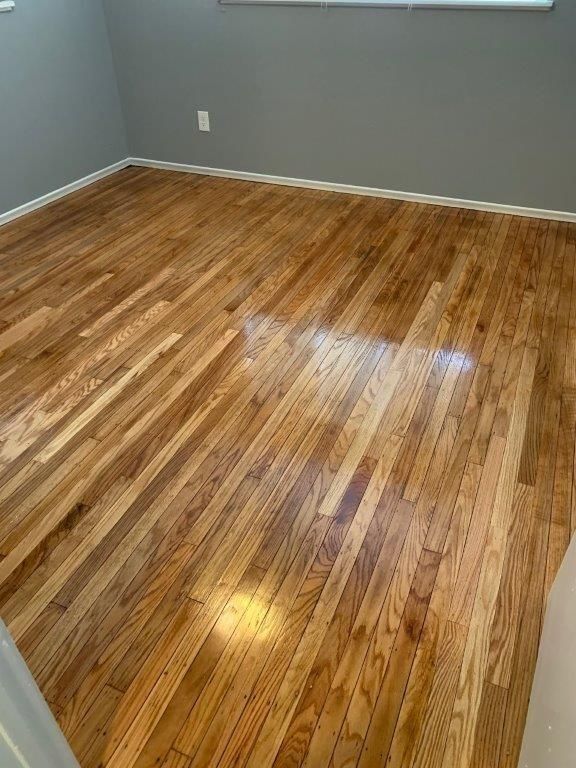 Wooden hardwood flooring in a room with gray walls.